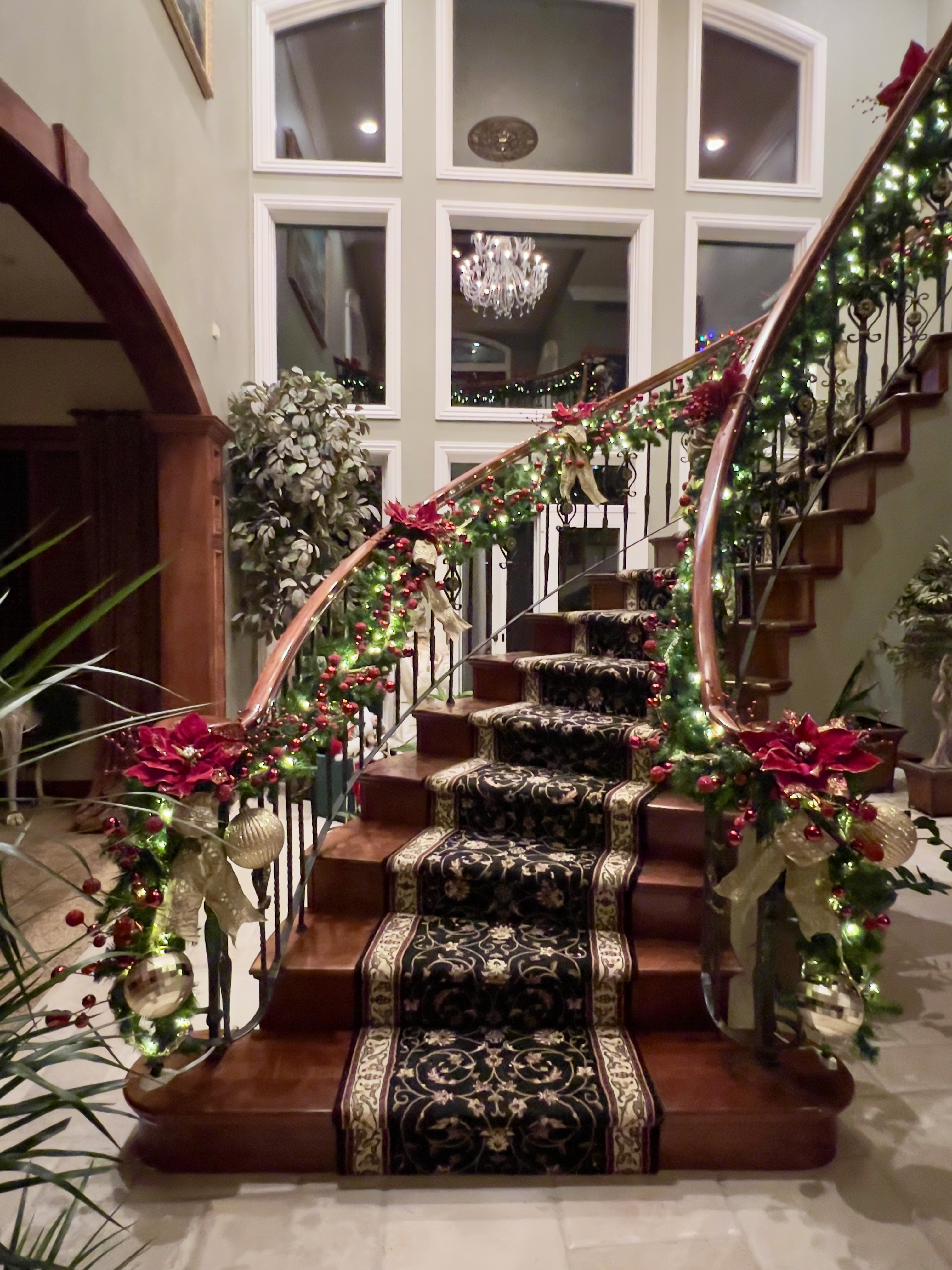 Holiday botanical decorating — grand staircase with lush garlands and holiday decor